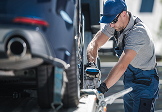 Towing Company Worker Securing Vehicle .