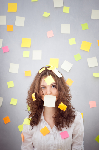 A stressed out woman covered in sticky notes.