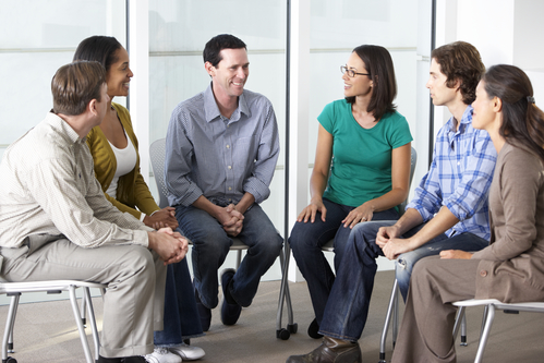 People sitting in a circle, discussing matters.