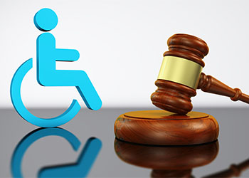 Paper cut out of person in wheelchair next to gavel