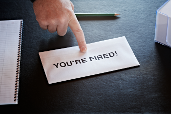 Man pointing to paper with You're Fired on it