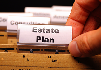 Person's Hand Holding a Card with Text "estate Plan"