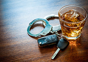 Alcohol glass, car keys and handcuffs, DUI Concept