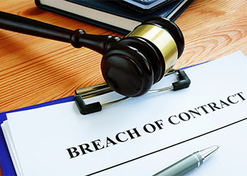 Breach of contract papers with pen and gavel