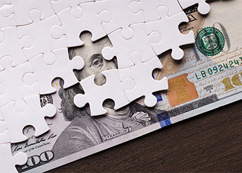 American dollar hidden under puzzle pieces