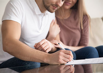 Close up of couple signing documents