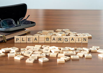 Plea bargain word or concept represented by wooden letter tiles