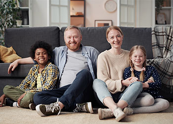 Happy Family With Adopted Child Sitting on Floor