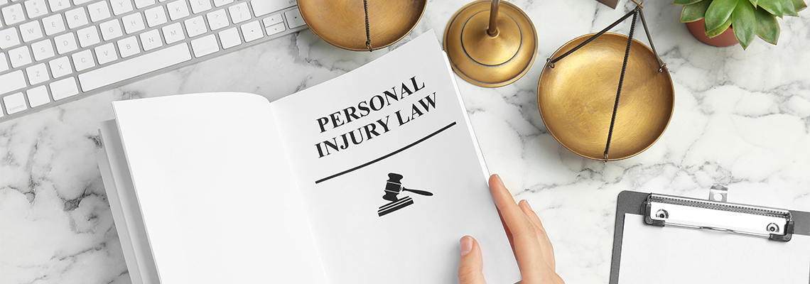 Woman turning page of book with words PERSONAL INJURY LAW at table