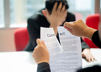 Man tearing contract agreement in office