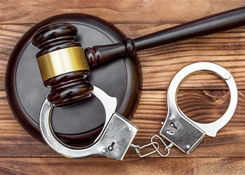 Gavel with stand and handcuffs on the wooden background