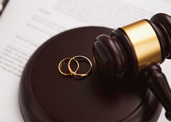 Divorce concept with gavel and wedding rings