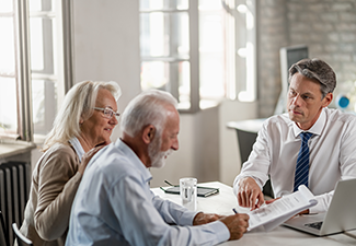 Financial advisor meeting with senior couple discussing will