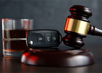 Law hammer, alcohol and car keys on wooden table
