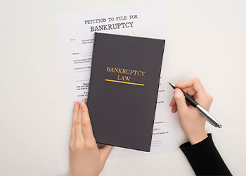 Woman with bankruptcy paper, law book and pen