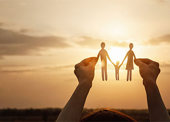 Child holding paper cut out of family figure