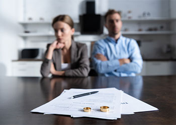 Couple sitting at table with divorce documents