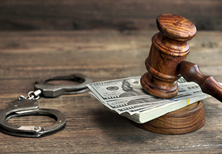 Dollar Banknotes, Handcuffs and Judge Gavel on Wood Table