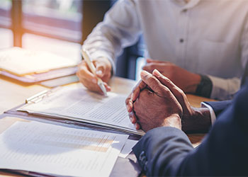 Businessman reading documents at meeting before signing legal contract