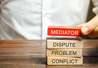 A Man Holds Wooden Blocks with The Word Mediator