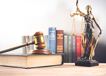 Law book with a wooden gavel and justice lady