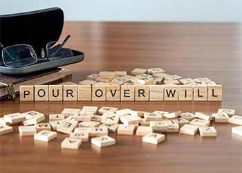 POUR OVER WILL word represented by wooden letter tiles