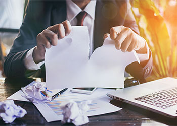 Stressed businessman tearing papers