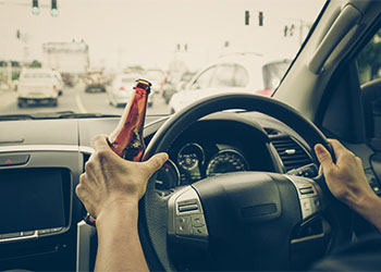 Driver holding alcoholic bottle while driving