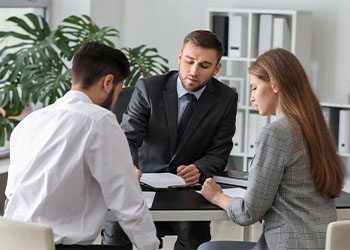 Unhappy young couple visiting divorce lawyer in office