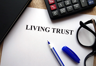 Living Trust Document, Pen, Glasses and Calculator on Desk