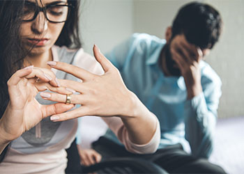 Wife removing ring from hand after argument with husband