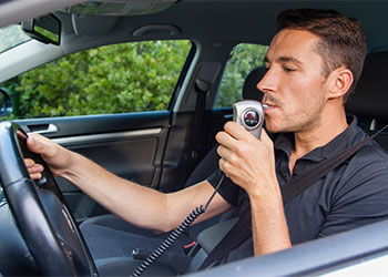 Man blowing into breathalyzer