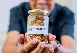 Elderly man hand showing a jar full of coins