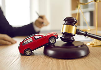 Little red toy automobile on table with sound block and gavel