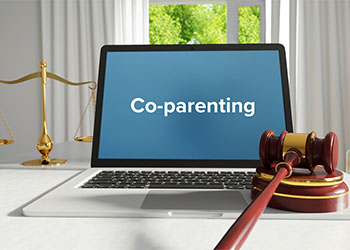 Laptop in the office with term Co-parenting and Gavel