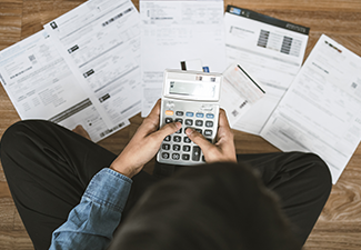 Man Sitting on the floor Stressed Looking at Bills