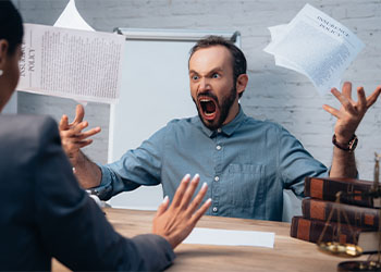 Angry man screaming while throwing documents in air near lawyer