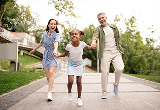 African-American daughter running while walking with parents