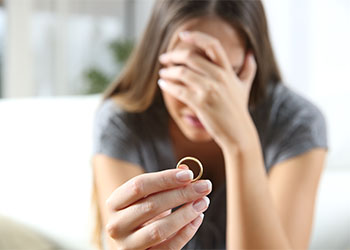 Sad women with ring in hand thinking of divorce