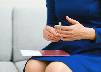 Women with passport in lap removing ring from hand