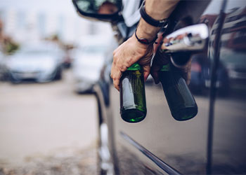 Driver holding beer bottle in hand