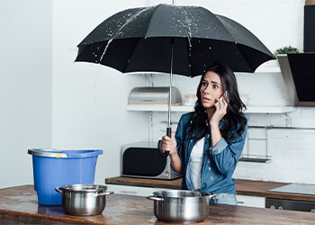 Women on phone complaining about water leakage in kitchen