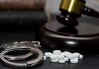 Judge's gavel with handcuffs, drugs on wooden table, drugs concept