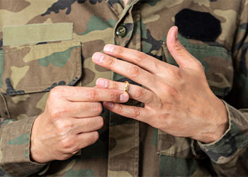 Hands of male soldier taking off his wedding ring