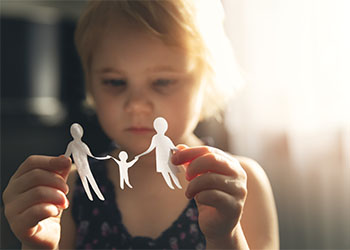 Little girl with paper family in hand
