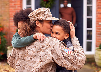 American Female Soldier In Uniform Returning Home To Family