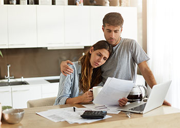 Frustrated Couples in kitchen looking at financial documents