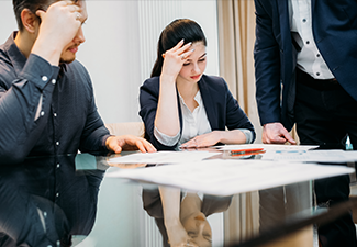 Man and woman sitting depressed at the lawyer office discussing divorce