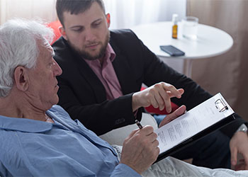 Old man reviewing last will document before signing