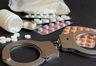 Drugs and handcuffs on table